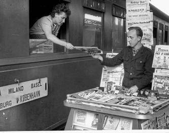 Zeitungen am Zug: Diese Dame kauft 1951 am Hauptbahnhof internationale Zeitungen am Fenster der D73.